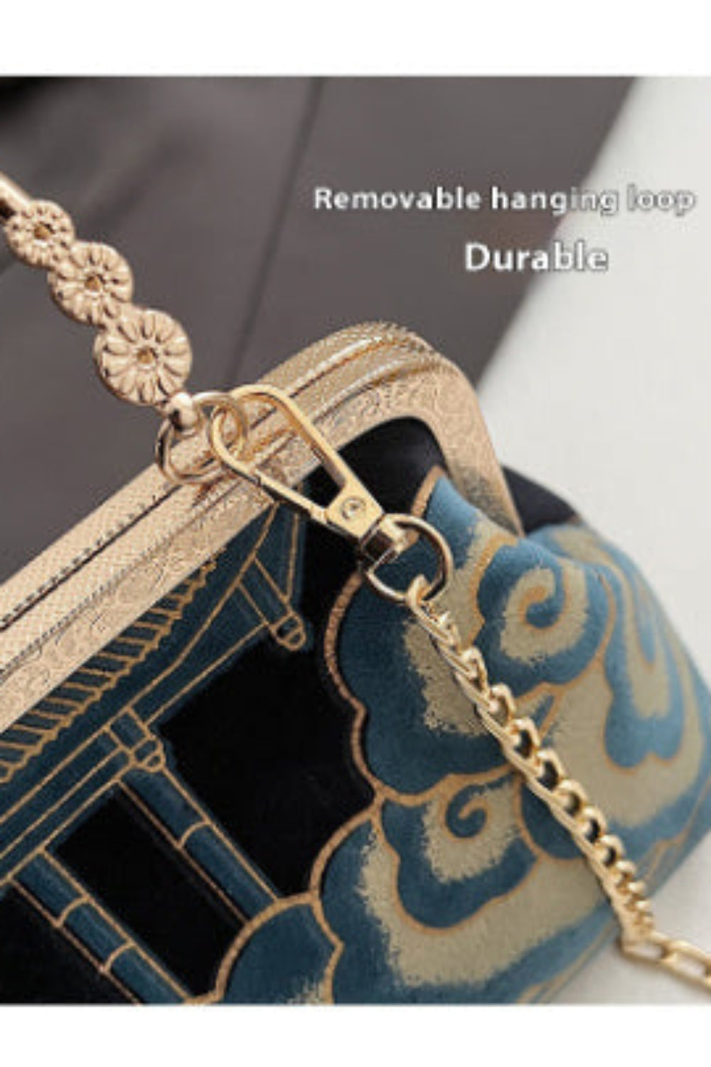 Gold handle with decorative elements on a handbag, featuring text 'Removable hanging loop' and 'Durable'.