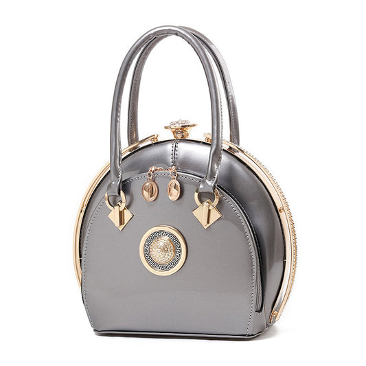 Gray handbag with gold accents on a white background