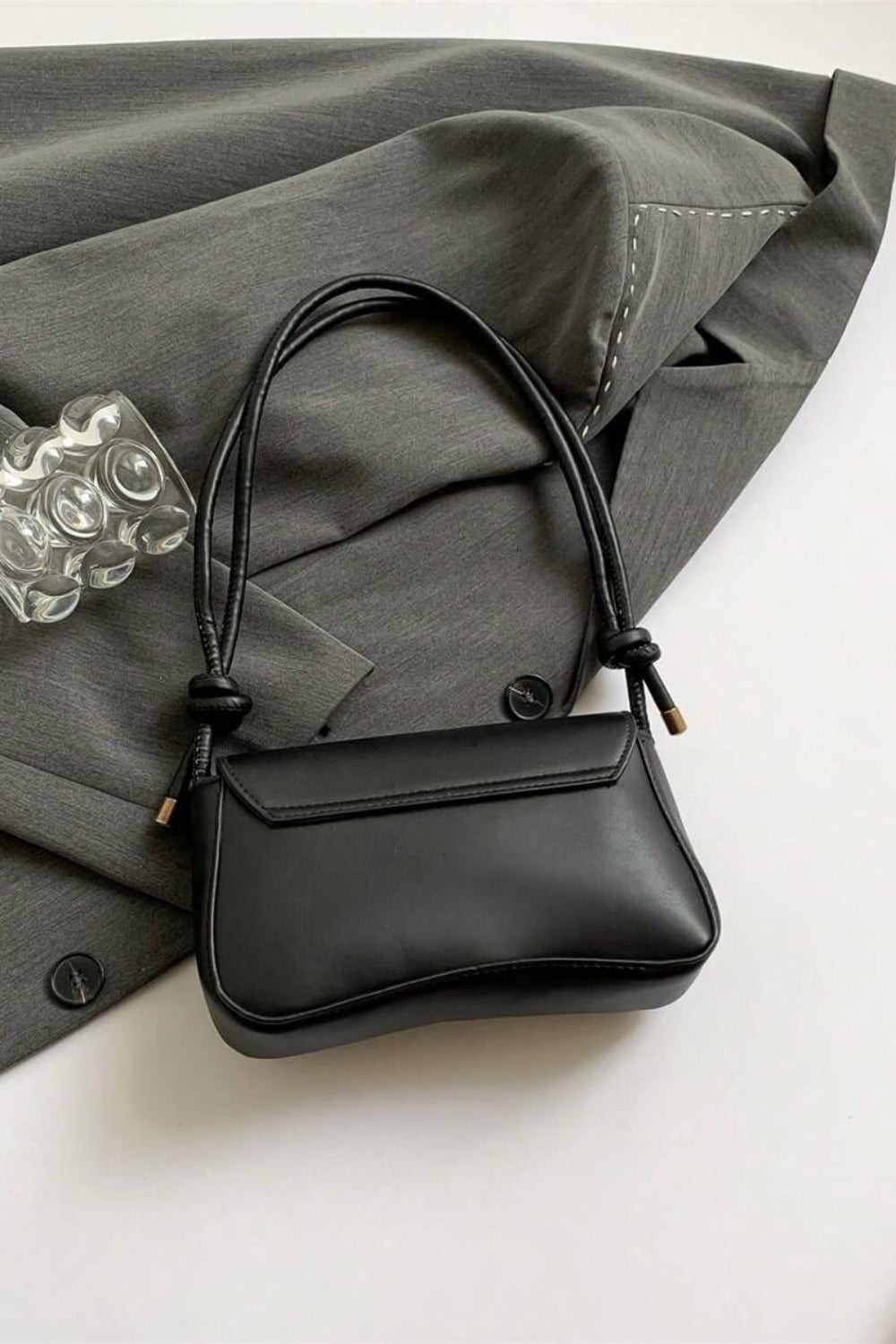 Black handbag on a gray fabric background