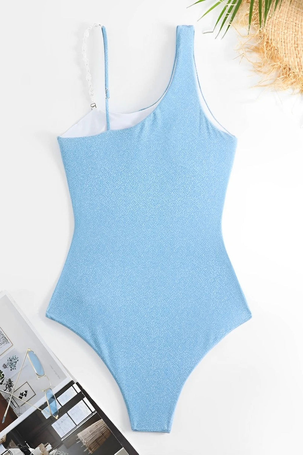 Blue swimsuit on a white surface with a blurred indoor background