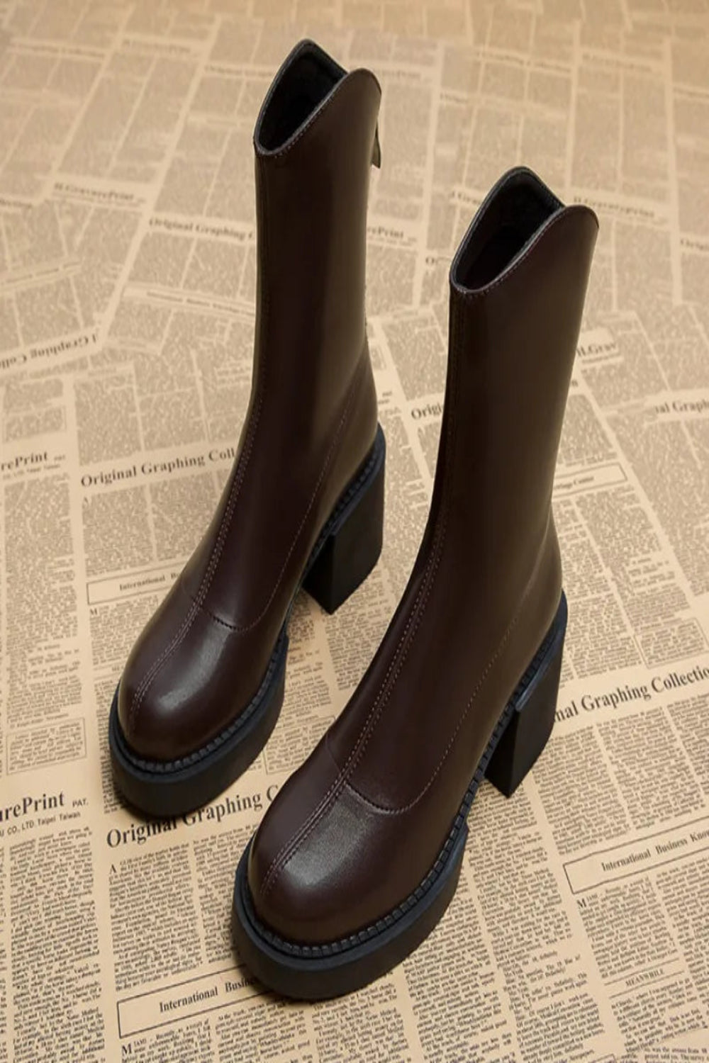 Pair of brown leather boots on a newspaper background