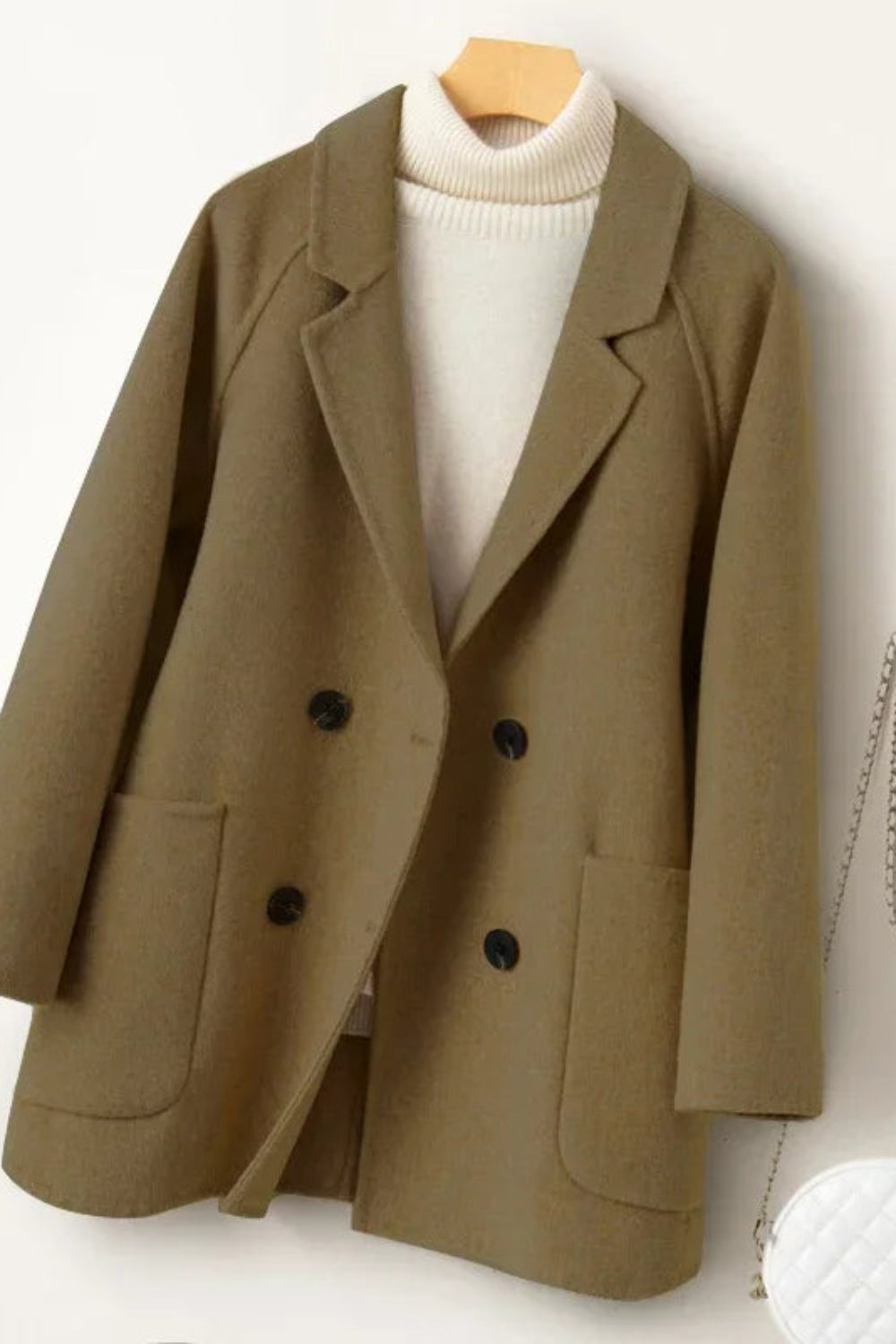 Brown blazer on a hanger with a white background