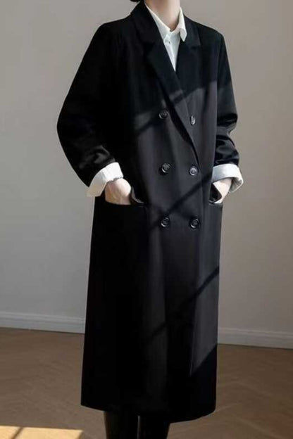 Black overcoat worn by a person against a plain background
