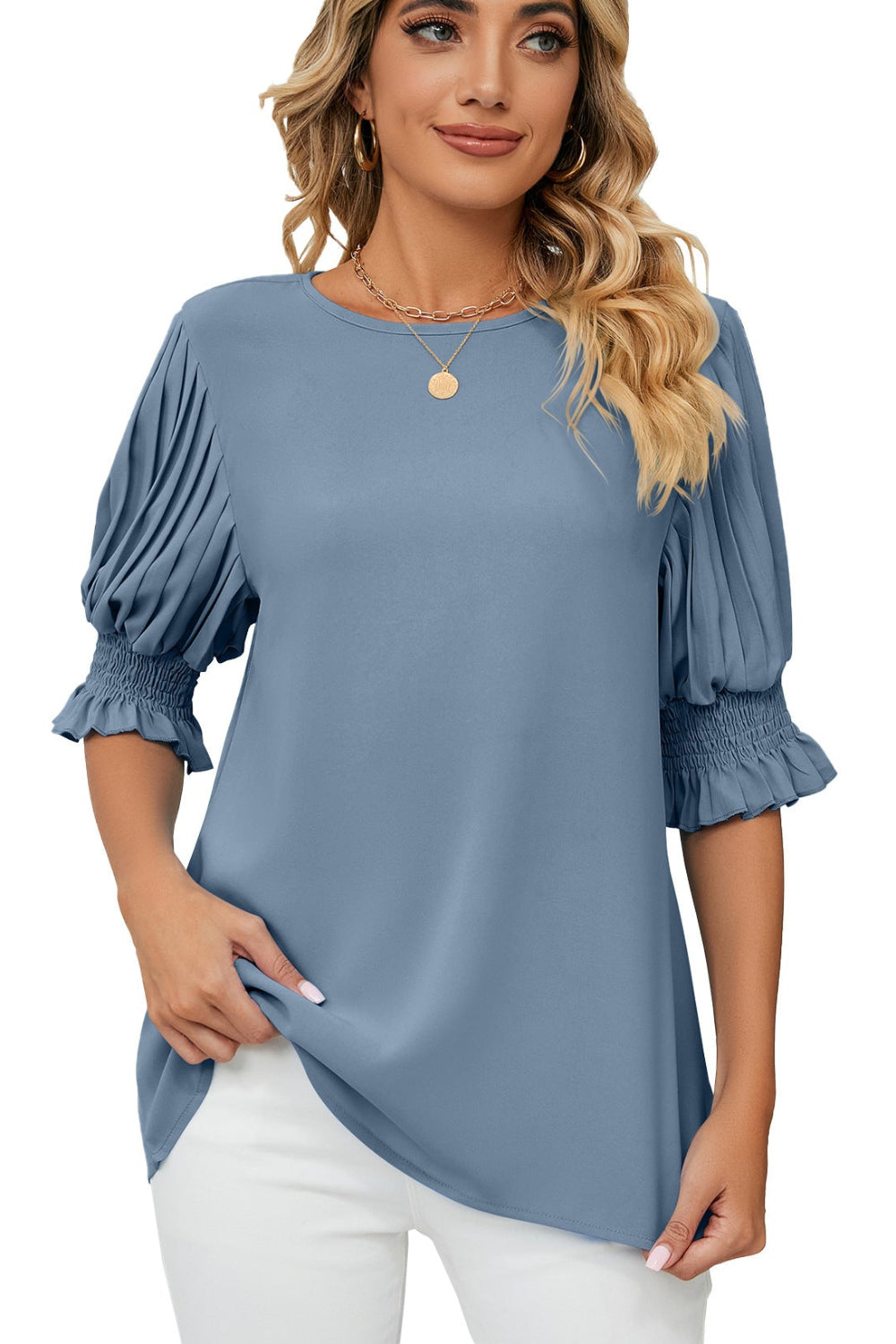 Woman wearing a blue blouse with puffed sleeves on a white background