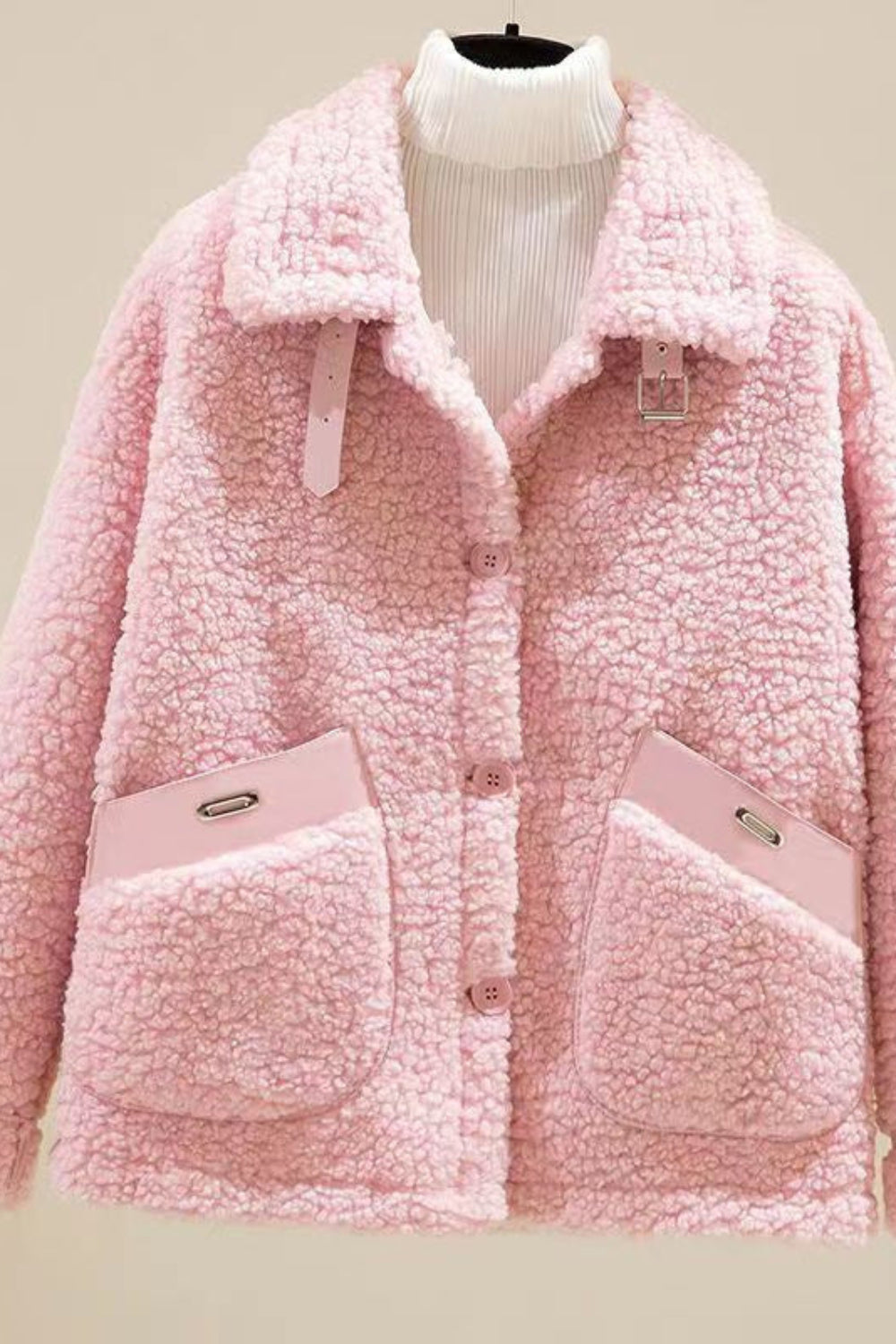 Pink sherpa jacket on a mannequin against a neutral background