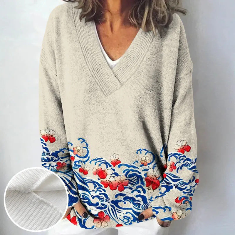 Gray sweater with colorful wave and cherry blossom design on sleeves against a white background