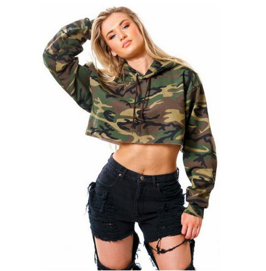 Woman wearing a camouflage hoodie and black shorts on a white background