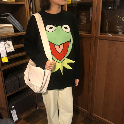 Person wearing a sweater with a frog design in a store setting