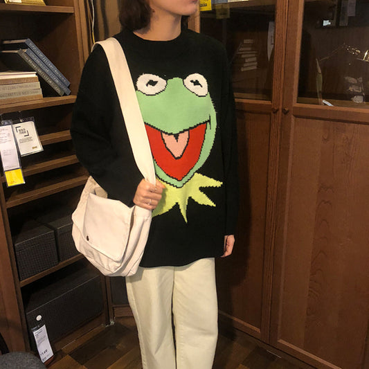 Person wearing a sweater with a frog design in a store setting