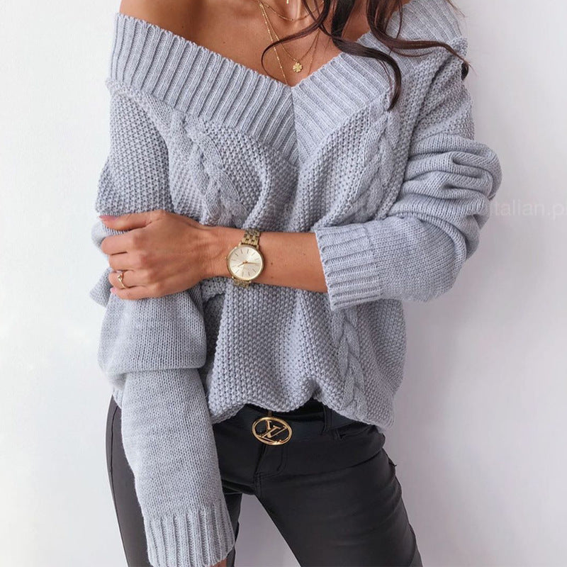 Person wearing a gray off-shoulder sweater with a plain background