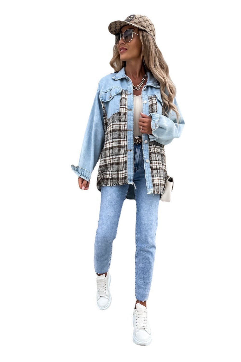 Woman wearing a denim jacket, plaid shirt, and jeans on a white background