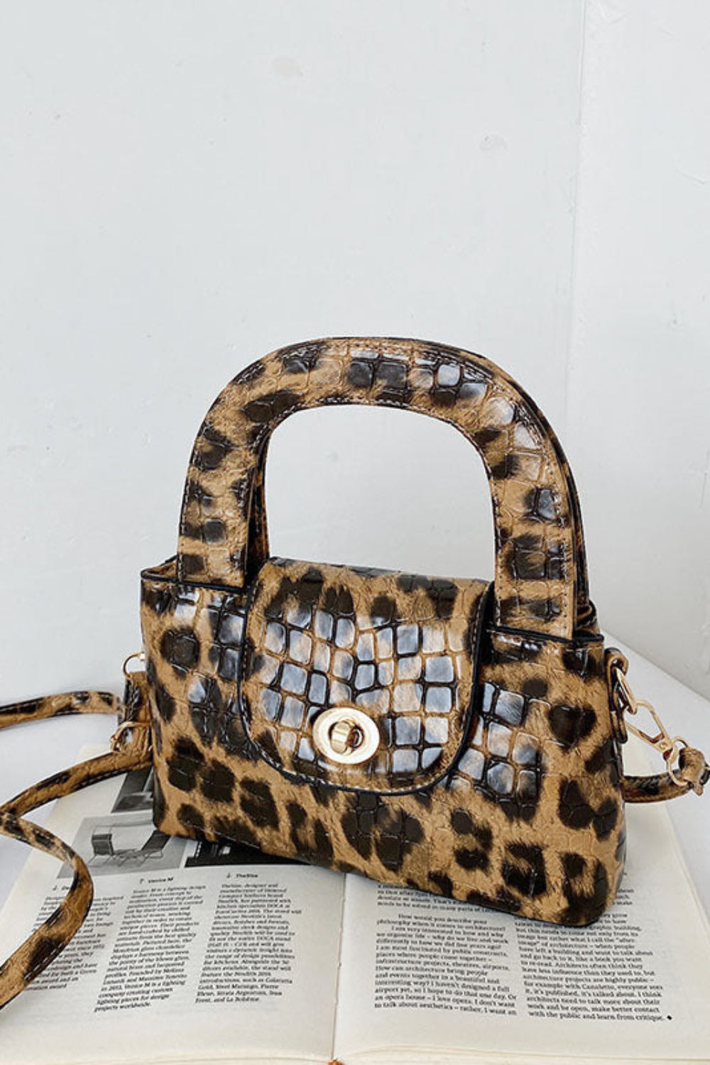 Leopard print handbag with studded details on a white surface