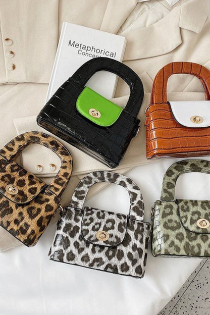 Collection of small handbags with leopard print and other patterns on a textured surface.