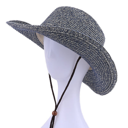Black and white straw hat with a chin strap on a mannequin head against a white background