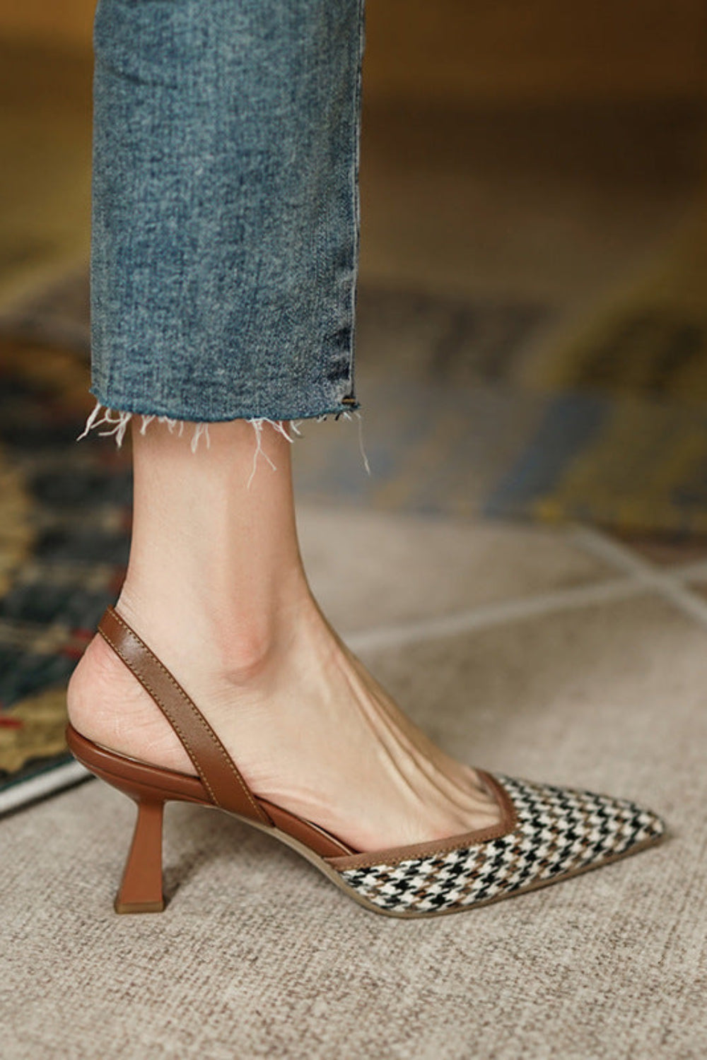 Brown high-heeled shoe with a checkered pattern on a blurred background