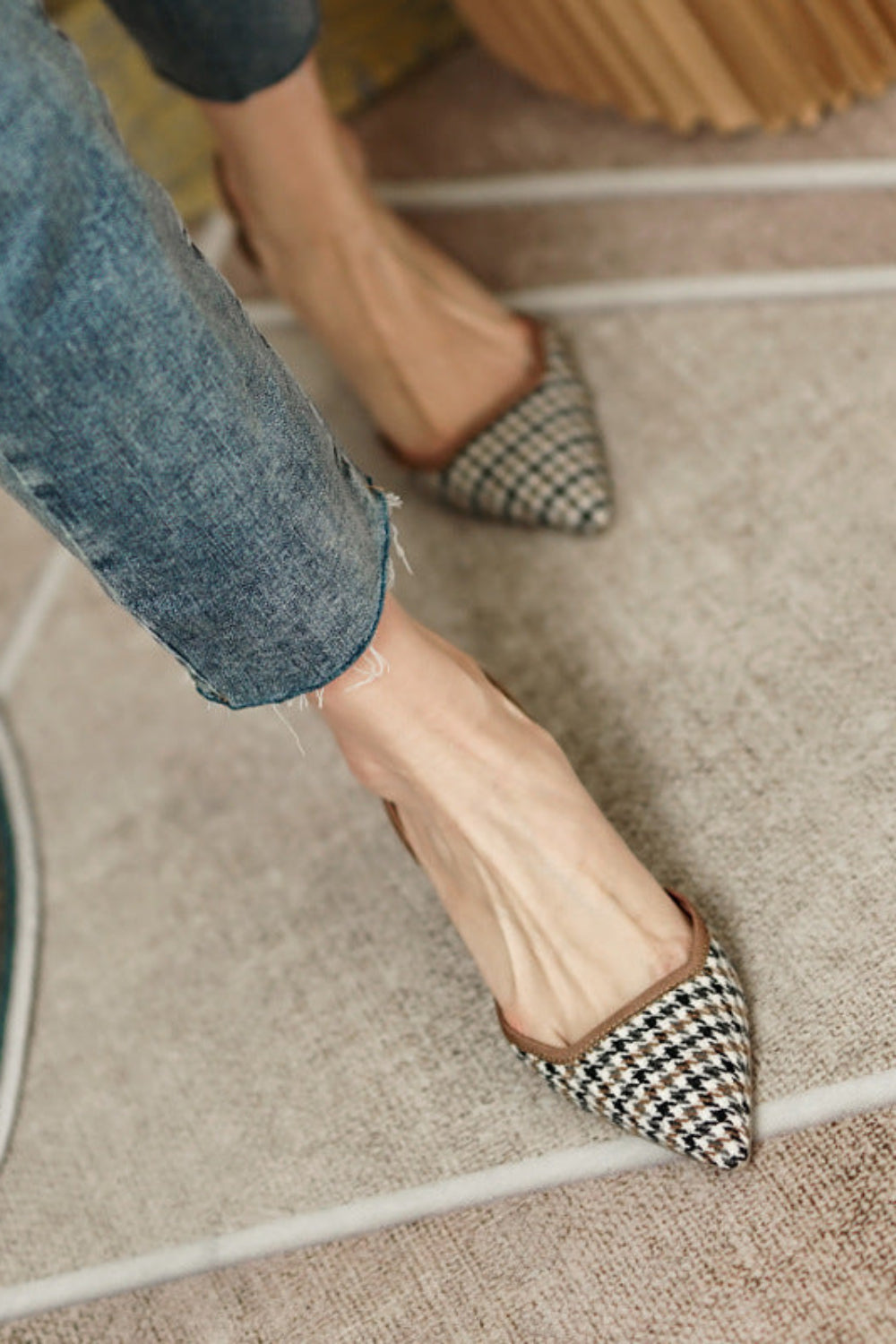 Person wearing checkered shoes on a carpeted floor