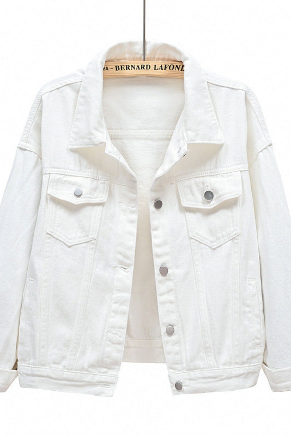 White denim jacket on a hanger with a white background