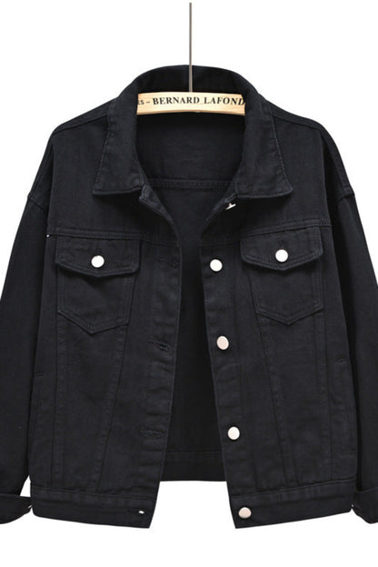 Black denim jacket on a hanger with a white background