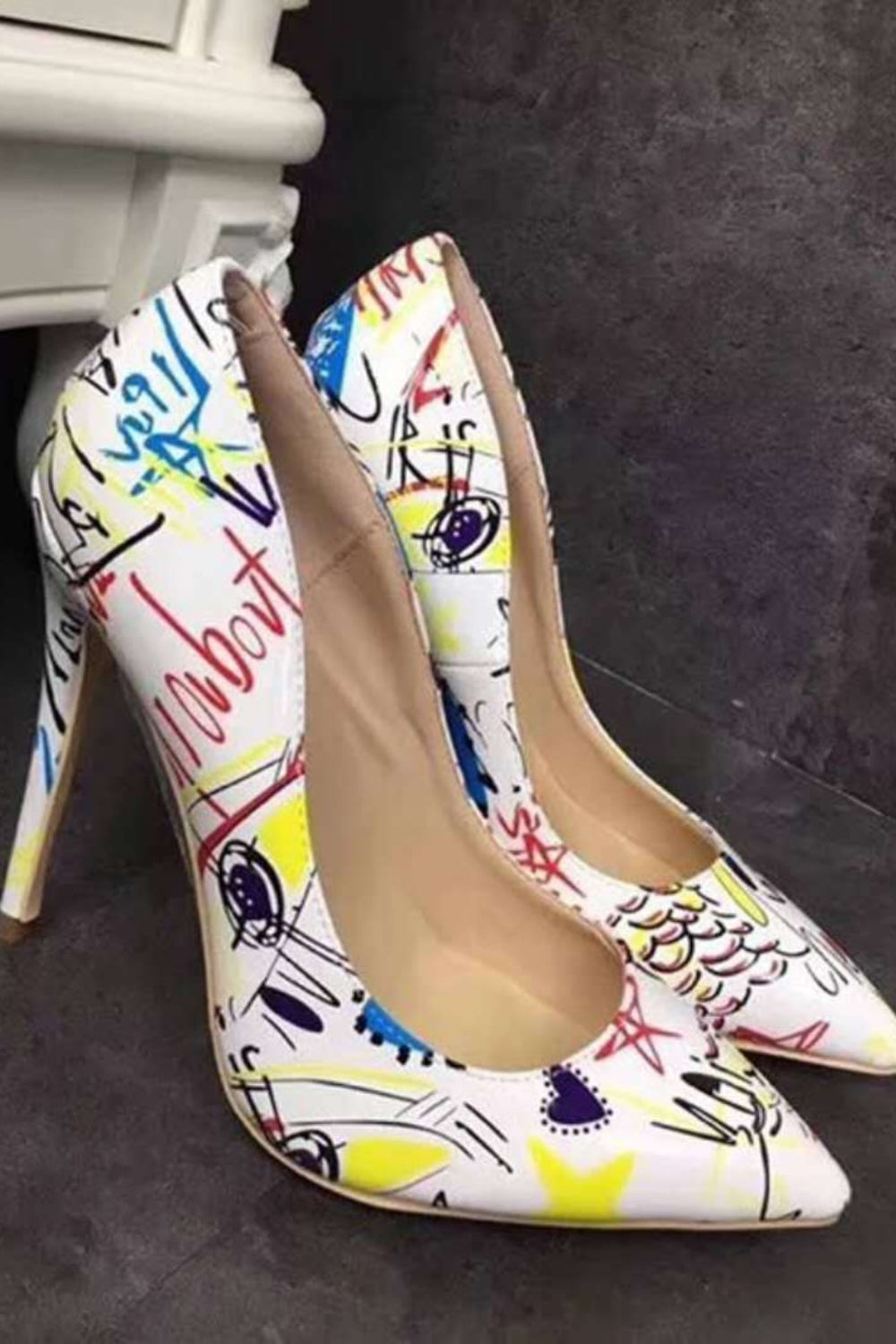 Colorful high-heeled shoes with abstract design on a dark background