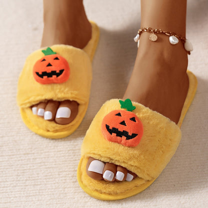 Yellow slippers with pumpkin faces on a neutral background