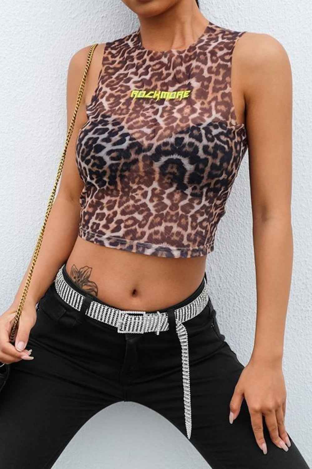 Person wearing a leopard print top with a brand logo against a white background