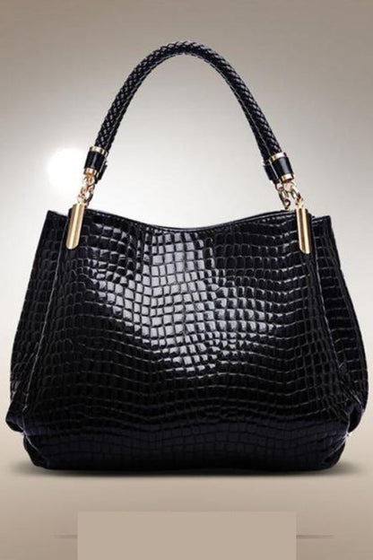 Black textured handbag with braided handle on a beige background