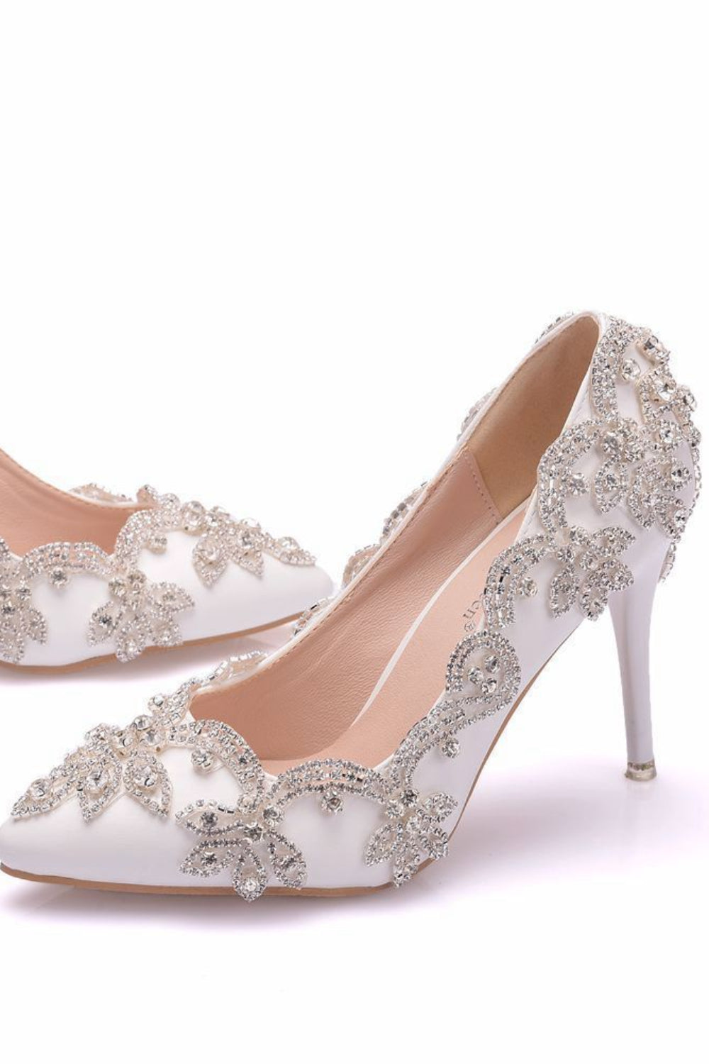 White high-heeled shoes with silver embellishments on a white background