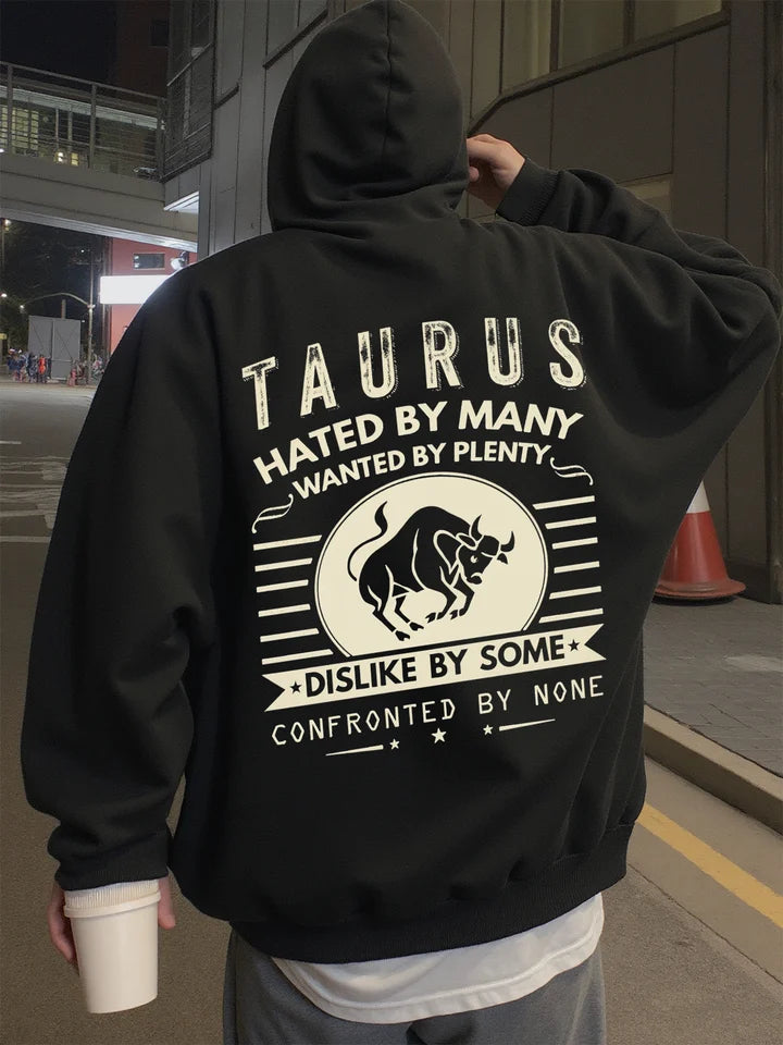 Person wearing a black hoodie with Taurus zodiac design and text.