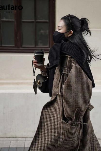 Person wearing a long coat and holding a coffee cup, with 'Lautaro' brand visible.