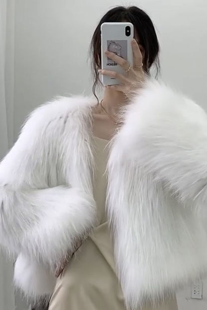 Person wearing a white fluffy coat taking a mirror selfie.