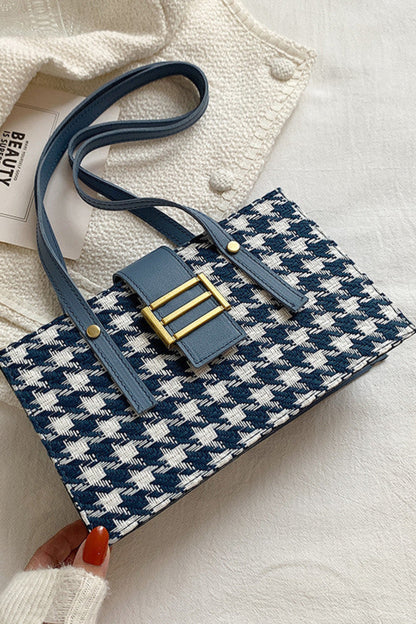 Blue and white houndstooth patterned pouch with gold accents on a light background