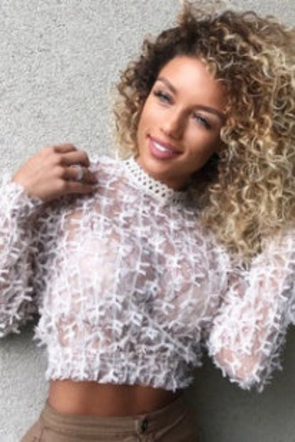 Woman wearing a sheer white blouse against a gray background