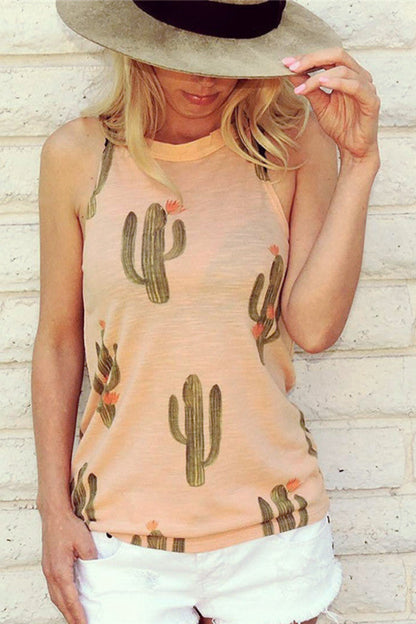 Woman wearing a peach tank top with cactus prints against a light brick wall.