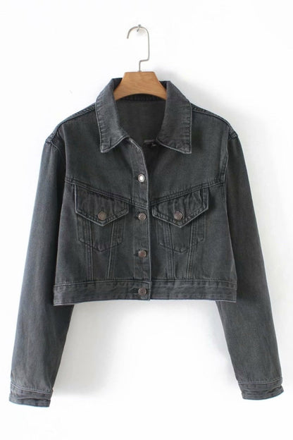 Black denim jacket on a hanger against a white background