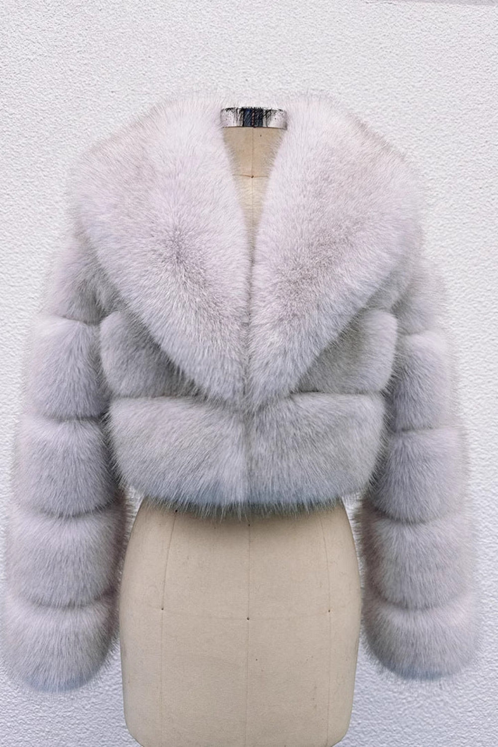 Light blue fur coat on a mannequin against a white background