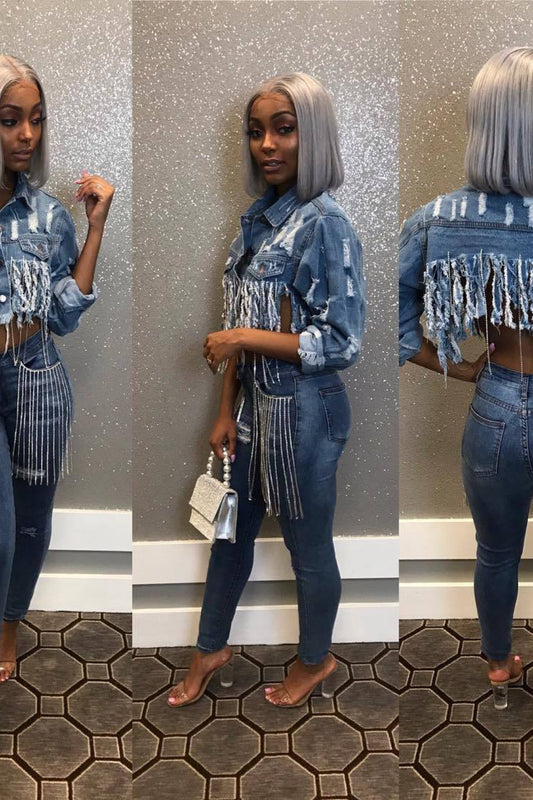 Woman wearing a denim outfit with fringe details in front of a mirror.