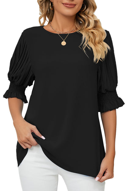 Woman wearing a black blouse with ruffled sleeves on a white background