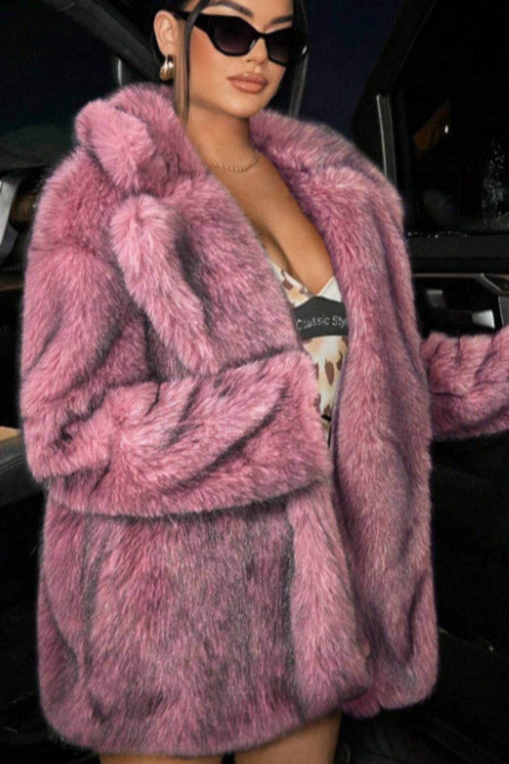 Person wearing a pink fur coat in a car interior.