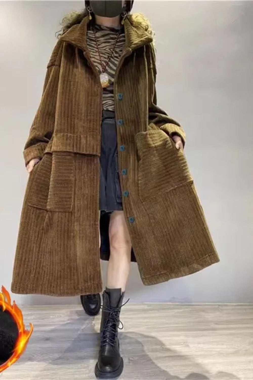 Person wearing a long brown coat with a flame icon on the left bottom corner.