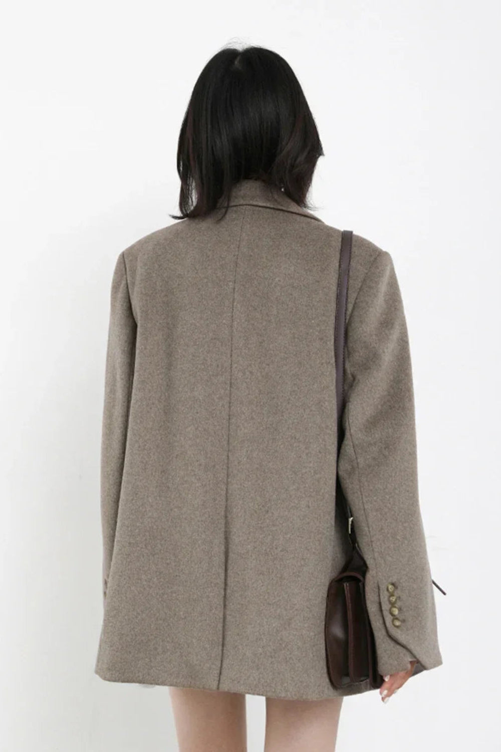 Person wearing a gray coat with a white background