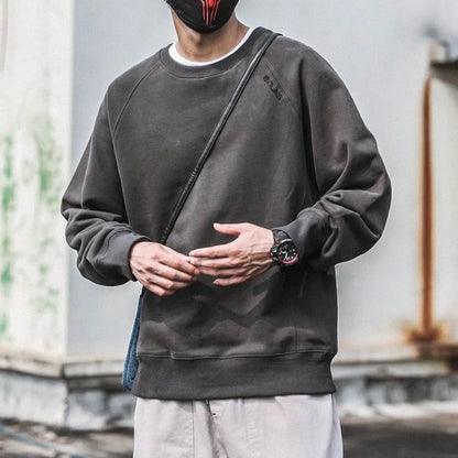 Person wearing a dark gray sweatshirt with a blurred background