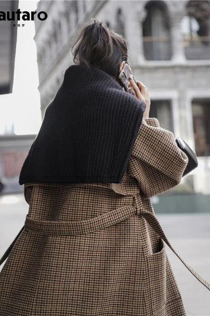 Person wearing a brown plaid coat with a blurred background
