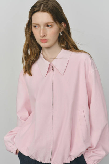 Woman wearing a light pink blouse against a plain background