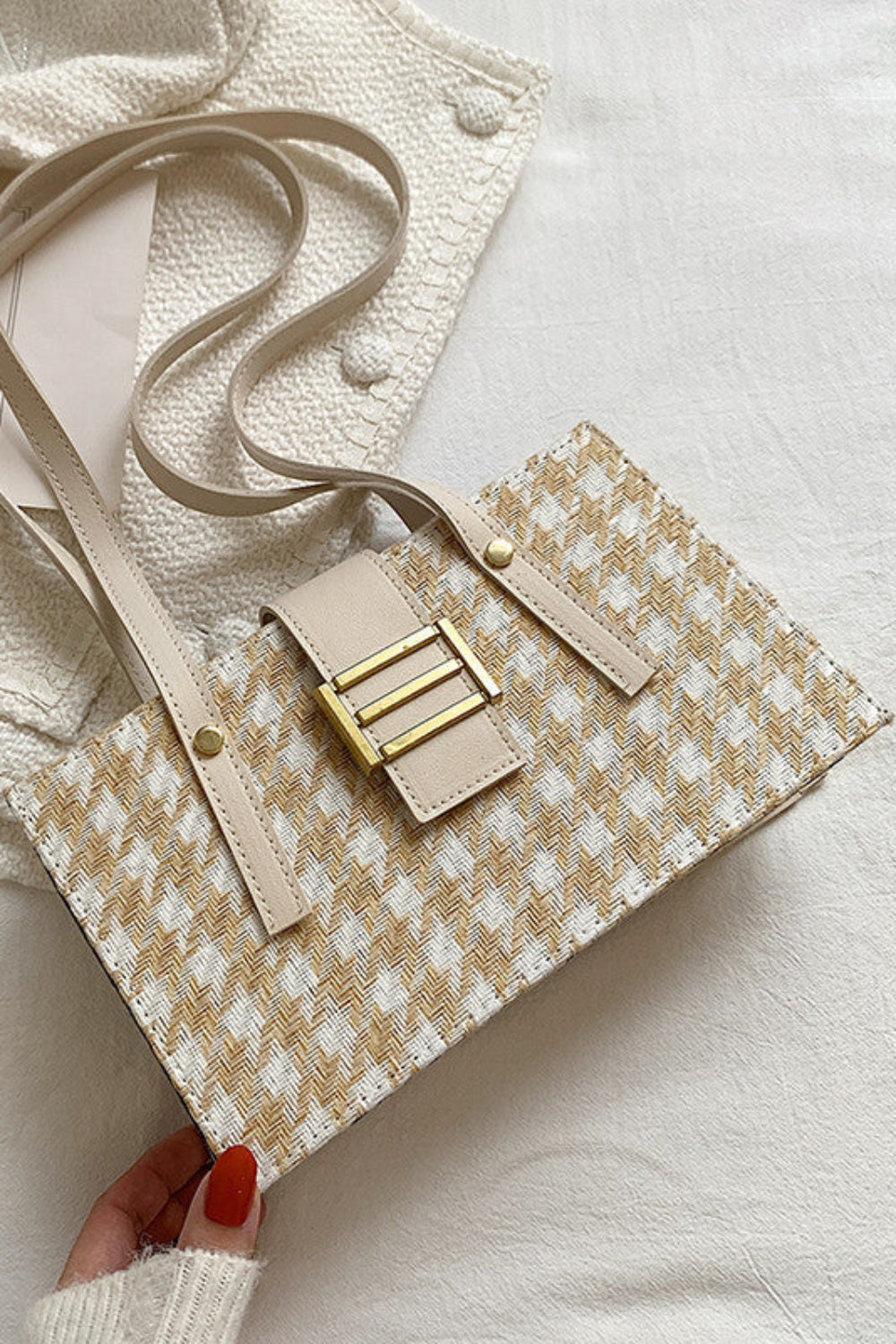 Beige handbag with gold accents on a light background