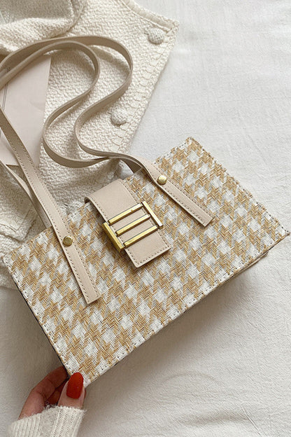 Beige handbag with gold accents on a light background