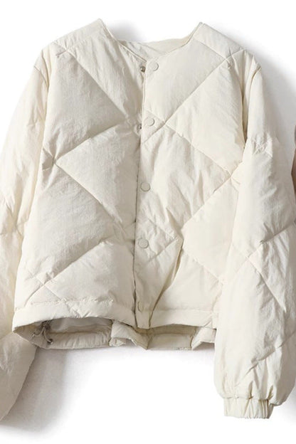 White quilted jacket on a white background with a handbag and shoes.