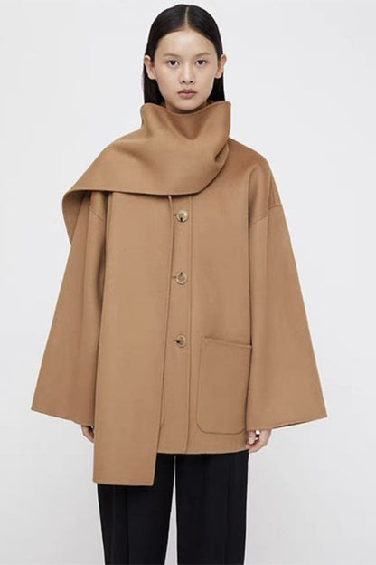 Woman wearing a tan coat on a white background