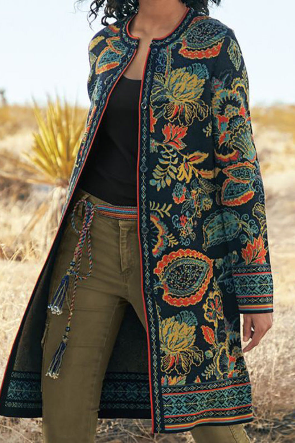 Person wearing a long, patterned coat in a desert setting