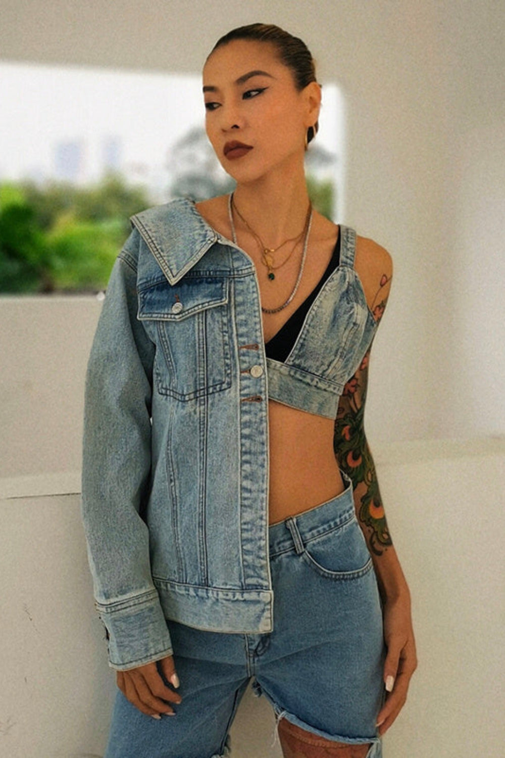 Woman wearing a denim jacket and shorts with a blurred background