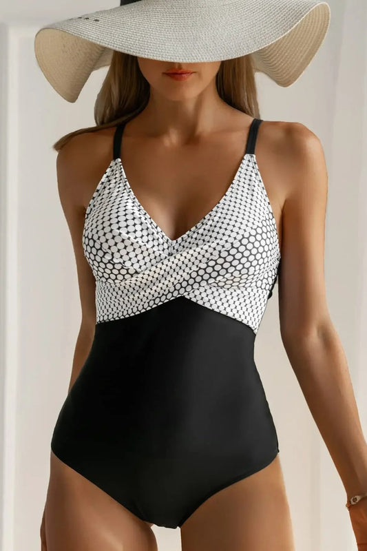 Woman wearing a black and white patterned swimsuit with a wide-brimmed hat.